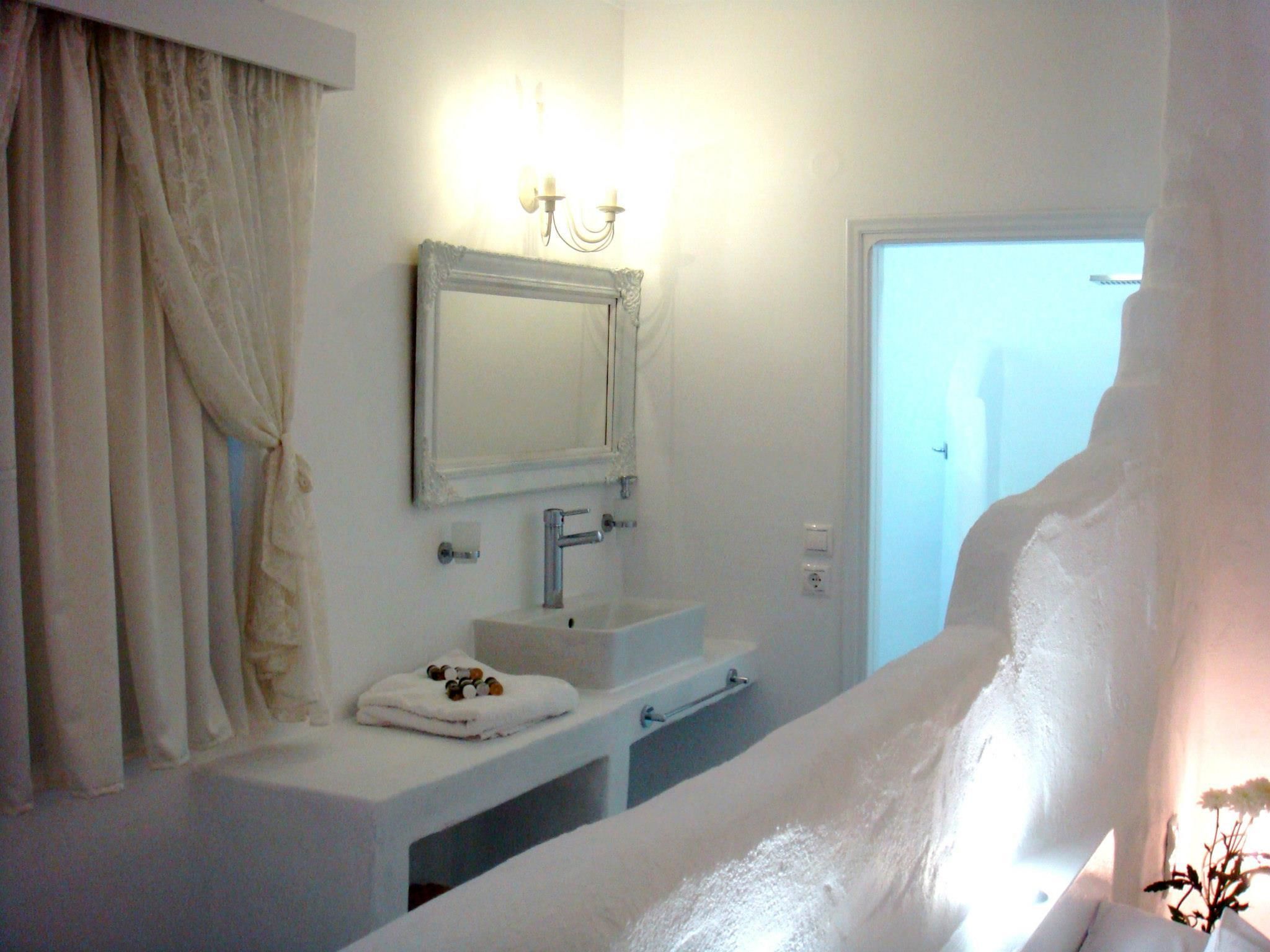 A bathroom with a white sink, mirror, and towel rack.