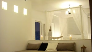 A bedroom with a bed, a bedside table, a nightstand, a mirror, and a window with curtains. - Blugreen Stegna B&B (Rhodes)