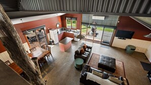 A modern interior with a kitchen, dining area, and living room. - Quins Gap Escapes (Bright)