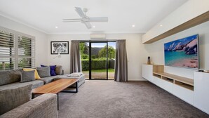 A modern living room with a sofa, coffee table, and TV. - Always Bright - A Bright Escape (BRIGHT)
