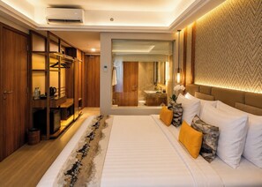 A hotel room with a large bed, a walk-in closet, a bathroom with a mirror, and a patterned wall.