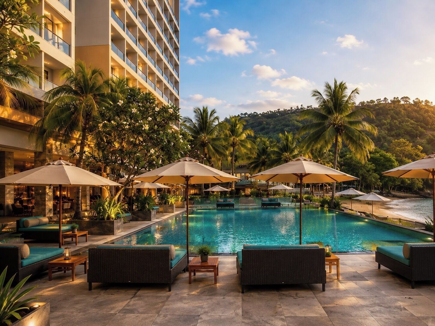 A hotel pool area with lounge chairs and umbrellas, surrounded by palm trees and a building.