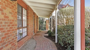 A brick building with large windows and a covered walkway. - Plum Pines Bright (BRIGHT)