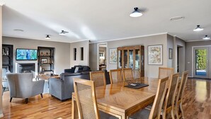 A spacious living area with a dining table, chairs, and a fireplace.