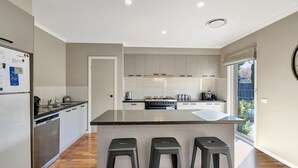 A modern kitchen with a central island, stainless steel appliances, and a view to the outdoors.