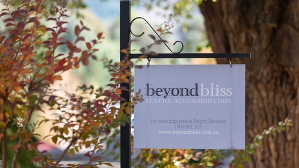 Schild mit der Aufschrift 'beyond bliss luxury accommodation' und Kontaktinformationen.