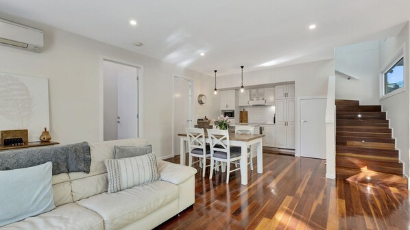 A modern living room with a sofa and a dining area.