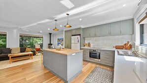 A modern kitchen with grey cabinets, a central island, and a built-in oven.