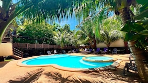 A swimming pool surrounded by palm trees and lounge chairs. - Infinity Sands Resort (San Juan)