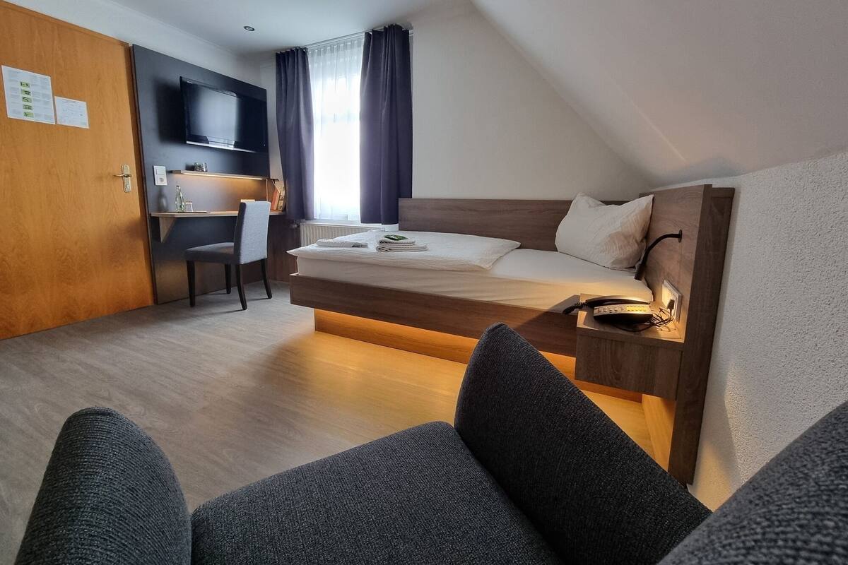Een moderne hotelkamer met een hoogslaper, een bureau en een stoel.