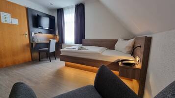 Una camera d'albergo moderna con letto a soppalco, una scrivania e una sedia.
