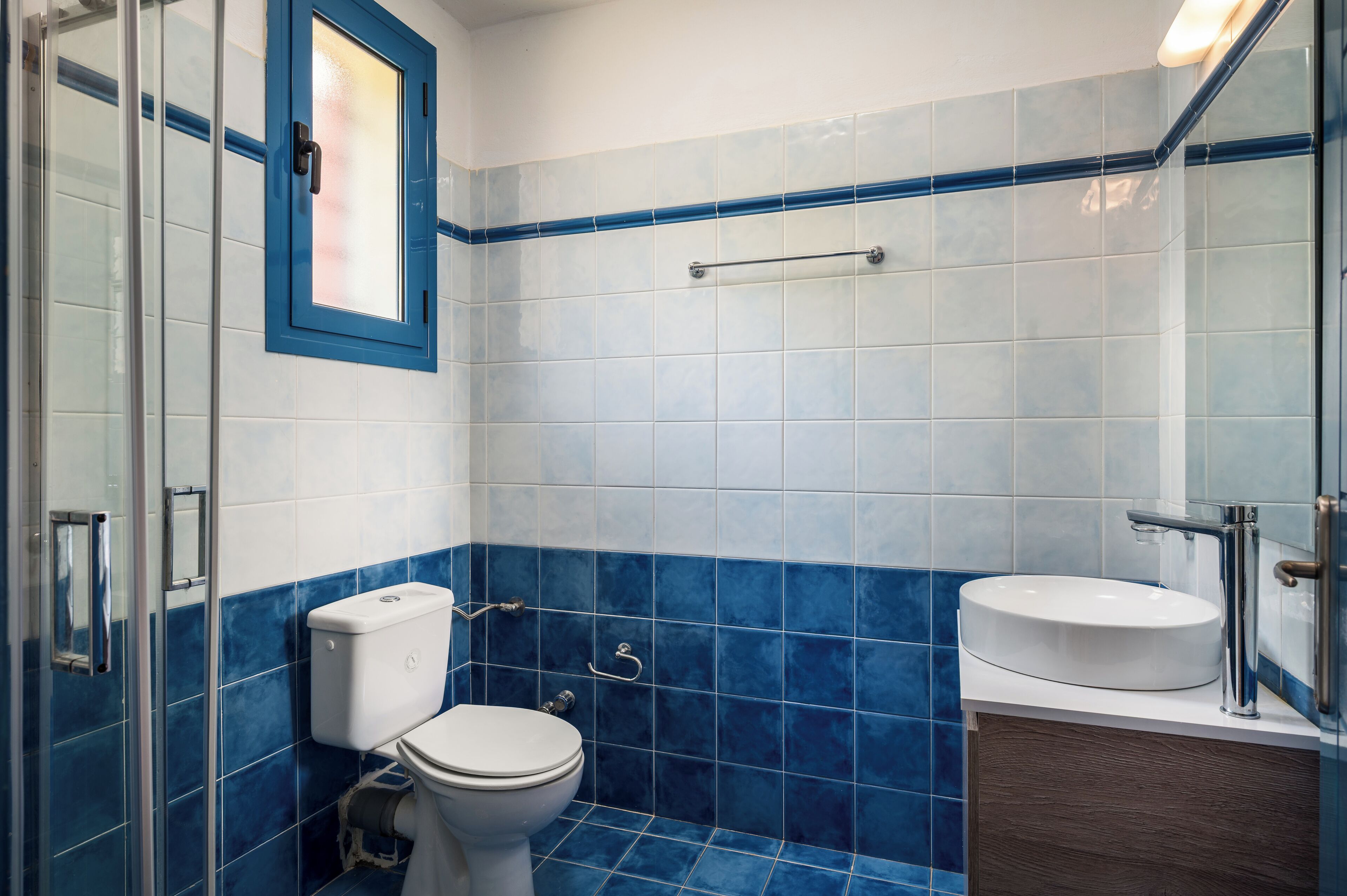 A bathroom with a toilet, sink, and shower area.