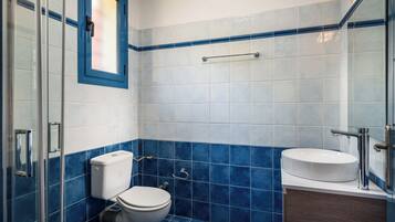 Ein Badezimmer mit Toilette, Waschbecken und Duschbereich.