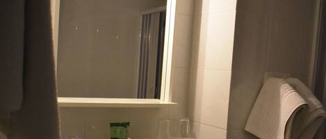 A bathroom with a white sink, a mirror, and a towel rack.