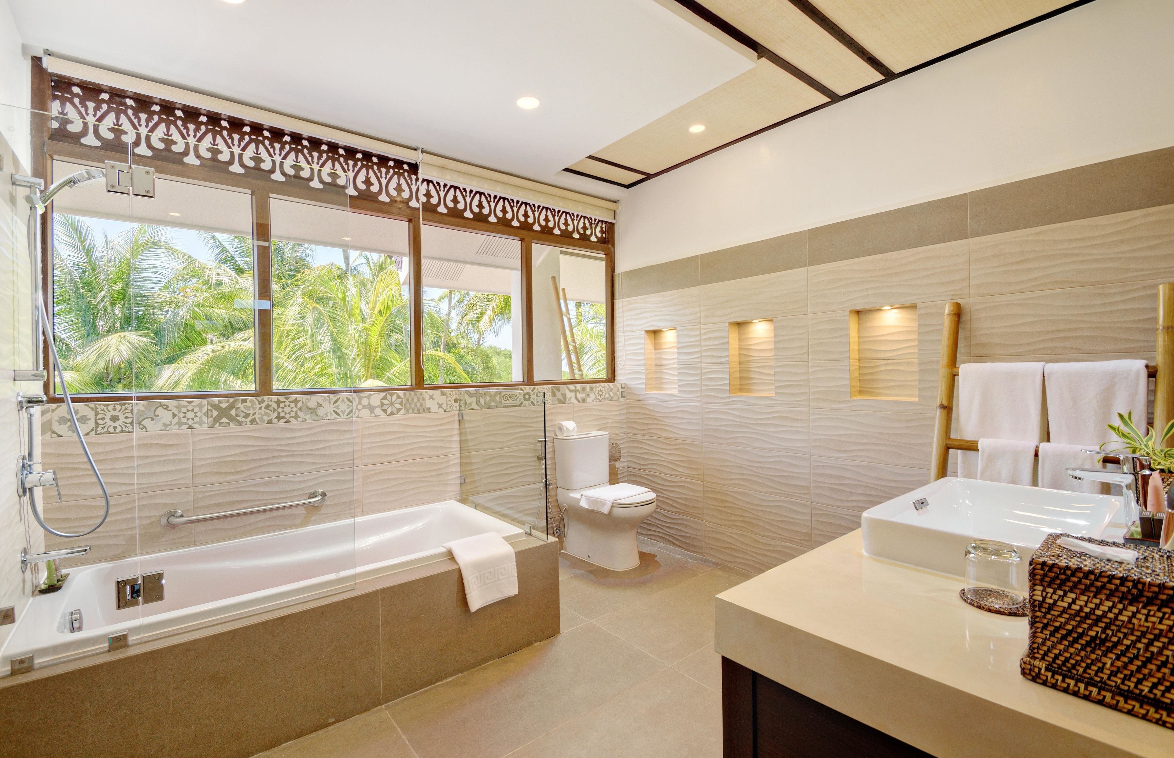 A modern bathroom with a bathtub, toilet, and vanity.
