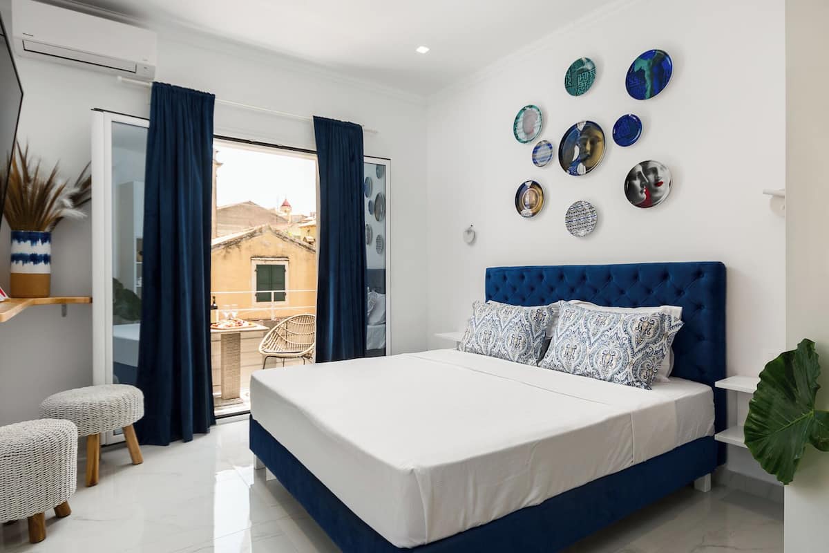 Un dormitorio con una cama grande, vistas al exterior y platos decorativos en la pared.