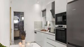 A modern kitchen with a Bosch refrigerator, a microwave, and a built-in oven. - Nicol House and Suite in Corfu Town by Konnect  (Corfu)