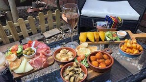 A glass table with various food items, a wine glass, and a basket of magazines. - The Kings Head Inn (Warwick)