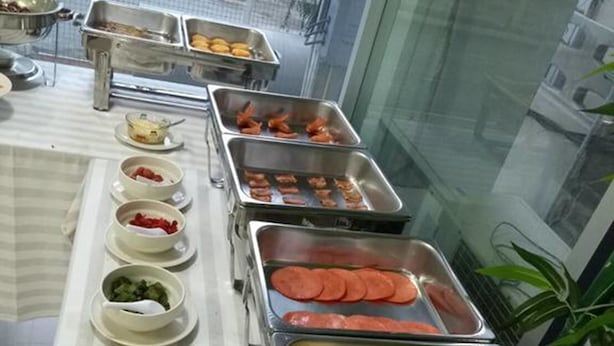 A buffet setup with various food items in metal containers, including scrambled eggs, sausages, and vegetables. - Choke-Set-Thee House (Ayutthaya)