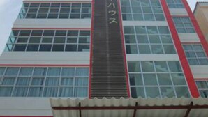 A multi-story building with a prominent vertical sign in the center. - Choke-Set-Thee House (Ayutthaya)