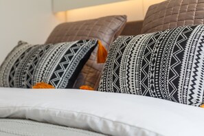 A bed with patterned pillows and a white comforter. - Goodge Street IV (London)