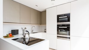 A modern kitchen with a central island, stainless steel appliances, and a minimalist design. - Goodge Street IV (London)