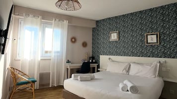 Een slaapkamer met een bed, een stoel, een bureau en een raam met gordijnen.