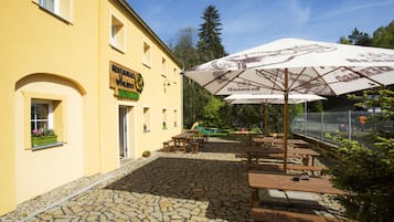 A yellow building with outdoor seating and umbrellas.