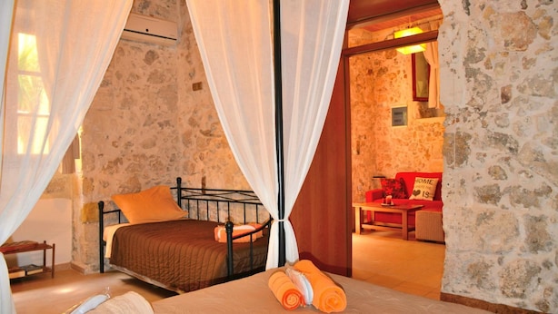 Une chambre à coucher avec un lit, une table de chevet, une lampe et une fenêtre avec des rideaux.
