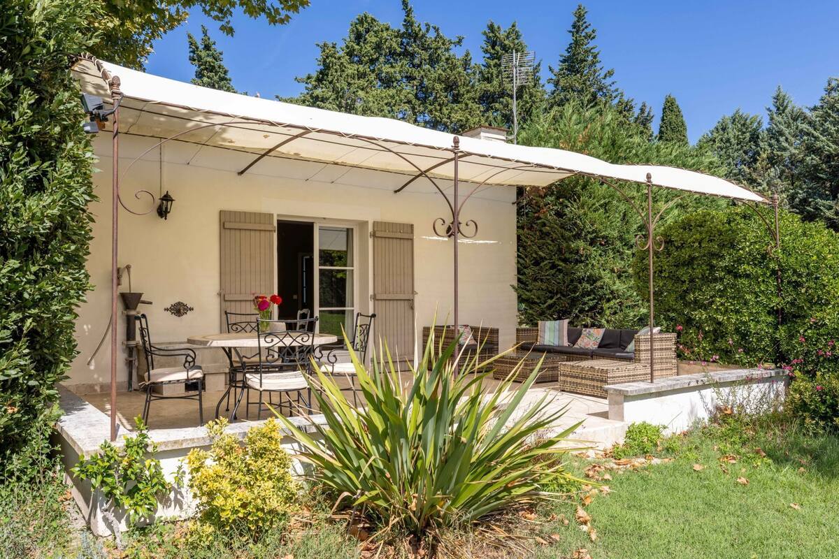 Ein Haus mit Terrasse, Sitzgelegenheiten im Freien und einem Garten.