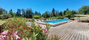 Relax by the pool surrounded by lush greenery and vibrant flowers.