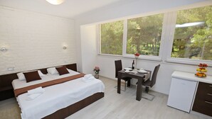 A bedroom with a bed, a desk, and a small refrigerator. - Deluxe Mkc Apartments (Zadar)