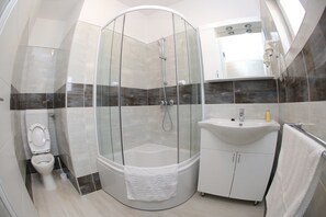 A modern bathroom with a glass-enclosed shower, a white sink, and a toilet. - Deluxe Mkc Apartments (Zadar)