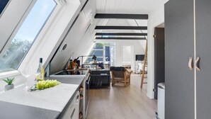 Una cuina moderna amb un gran finestral, zona de menjador i un espai oberta.