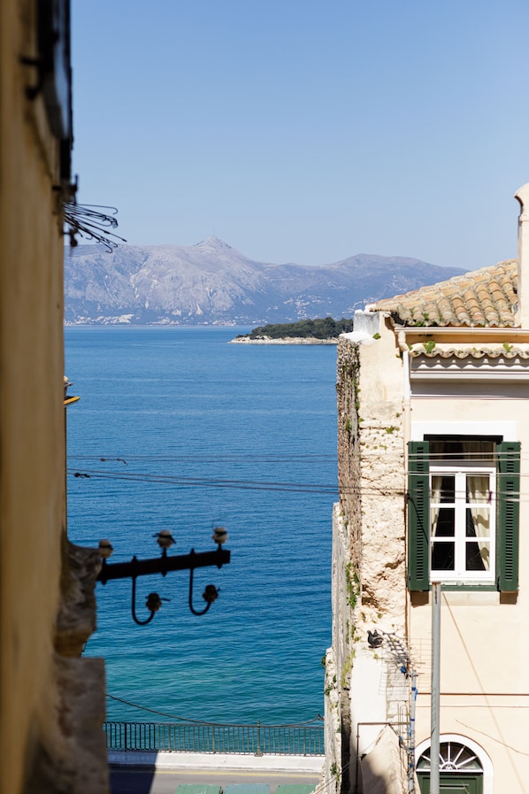 A coastal building with a view of the sea and mountains in the background.