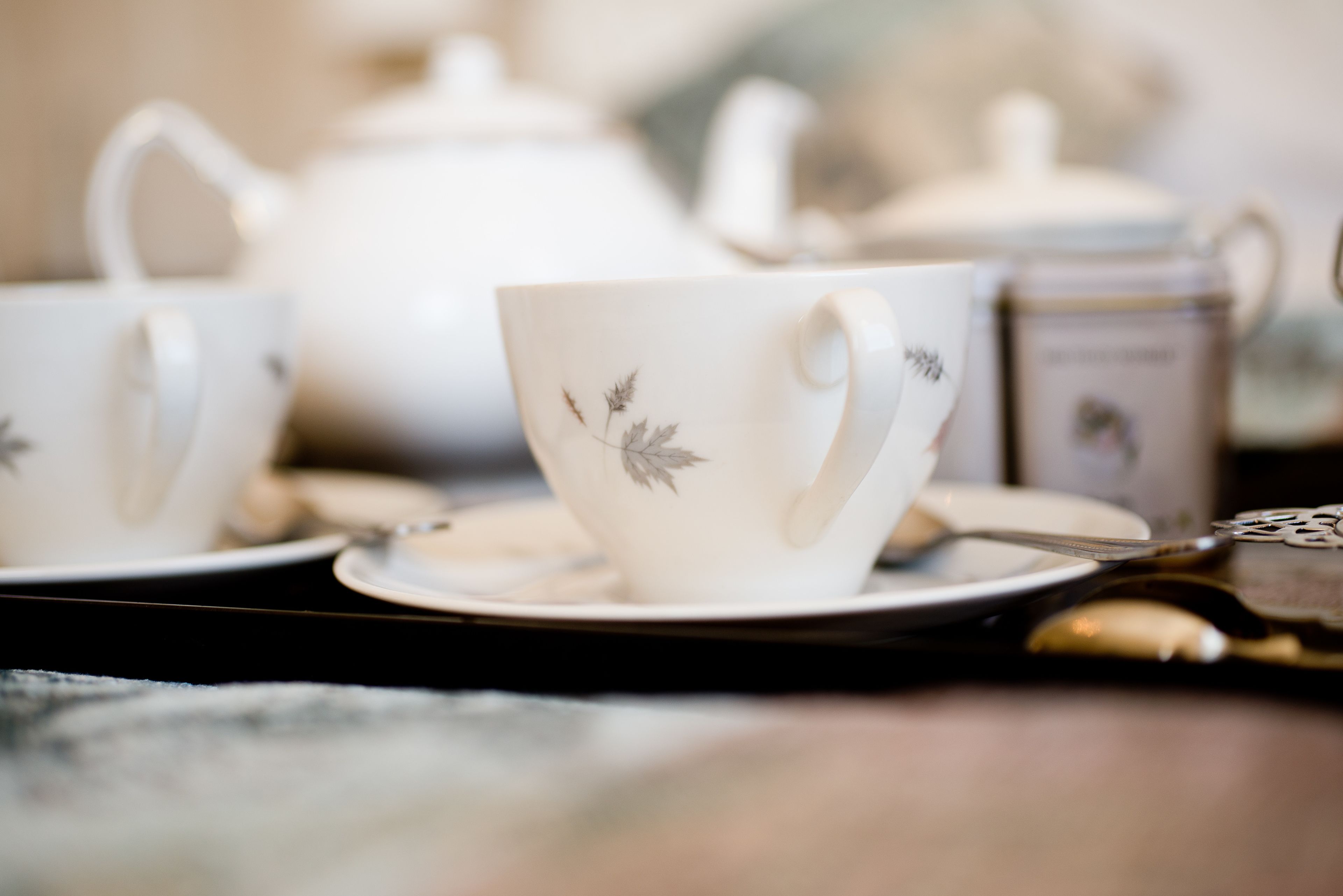 A tea set with cups and saucers on a tray.