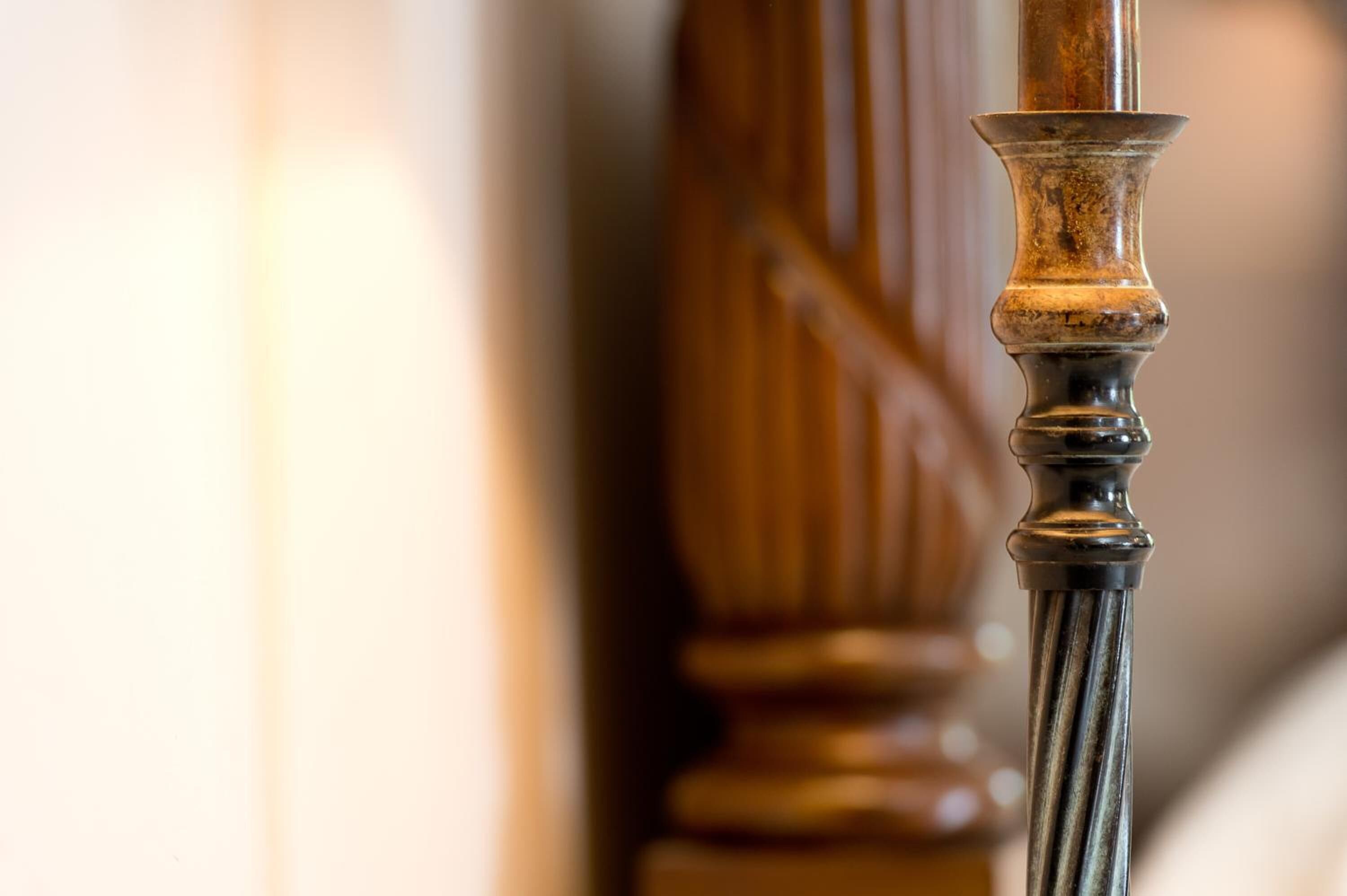 A close-up of a wooden balustrade with a metal handrail.