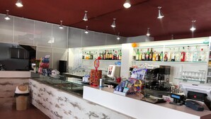 A bar area with a marble counter, shelves of beverages, and a coffee machine. - La Staffa B&B Ristorante (Ugento)