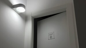 A door with a sign reading "ROOM 101" and a wall-mounted light fixture above it. - La Staffa B&B Ristorante (Ugento)