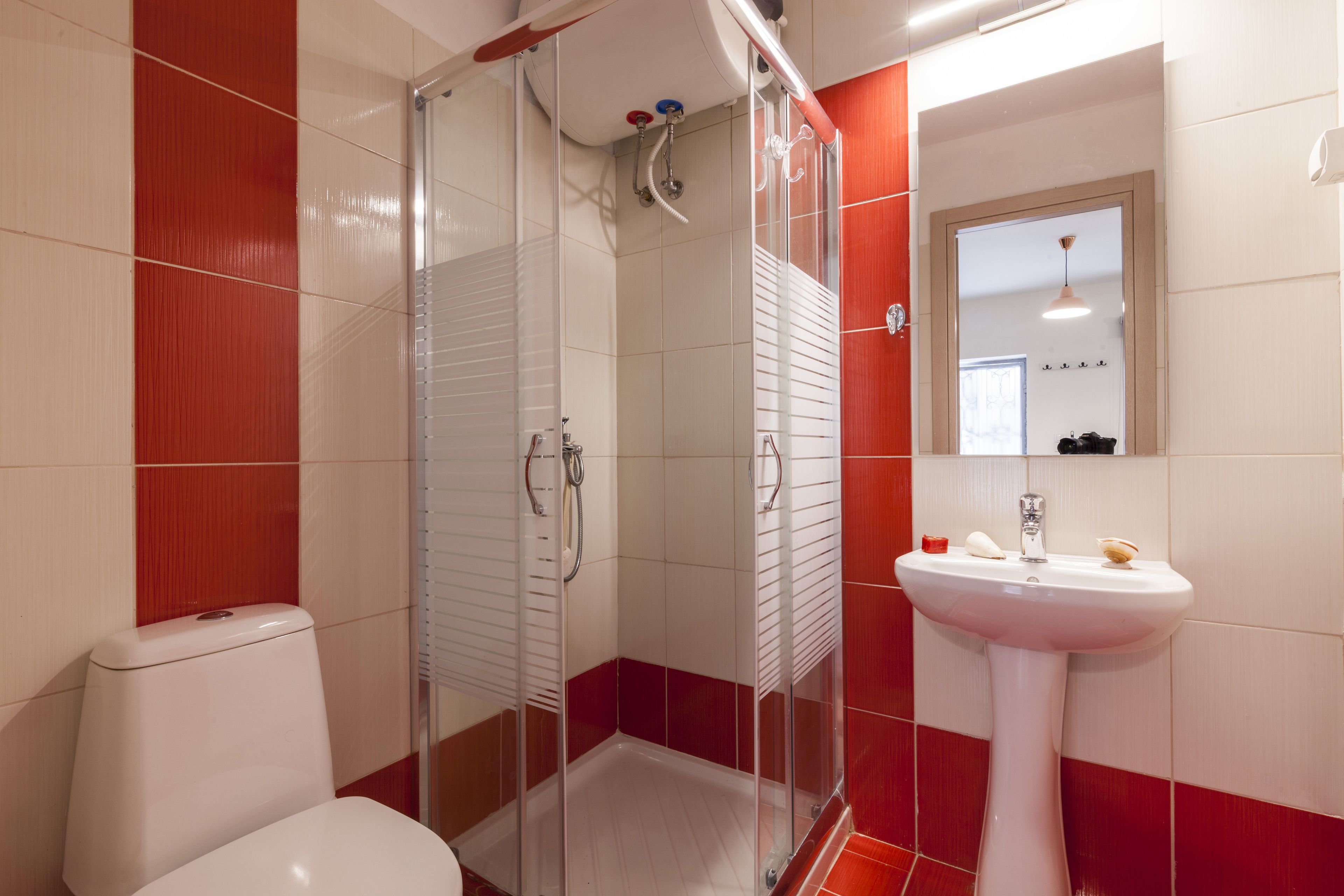 Une salle de bain avec une douche à parois de verre, un lavabo blanc et des toilettes.