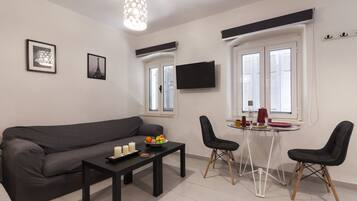 Studio, 2 lits une place, rez-de-chaussée | Coin séjour | Télévision à écran plat