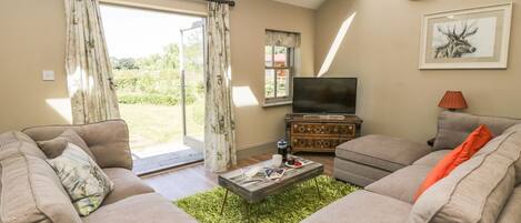 A living room with two sofas, a coffee table, a TV, and a painting on the wall.