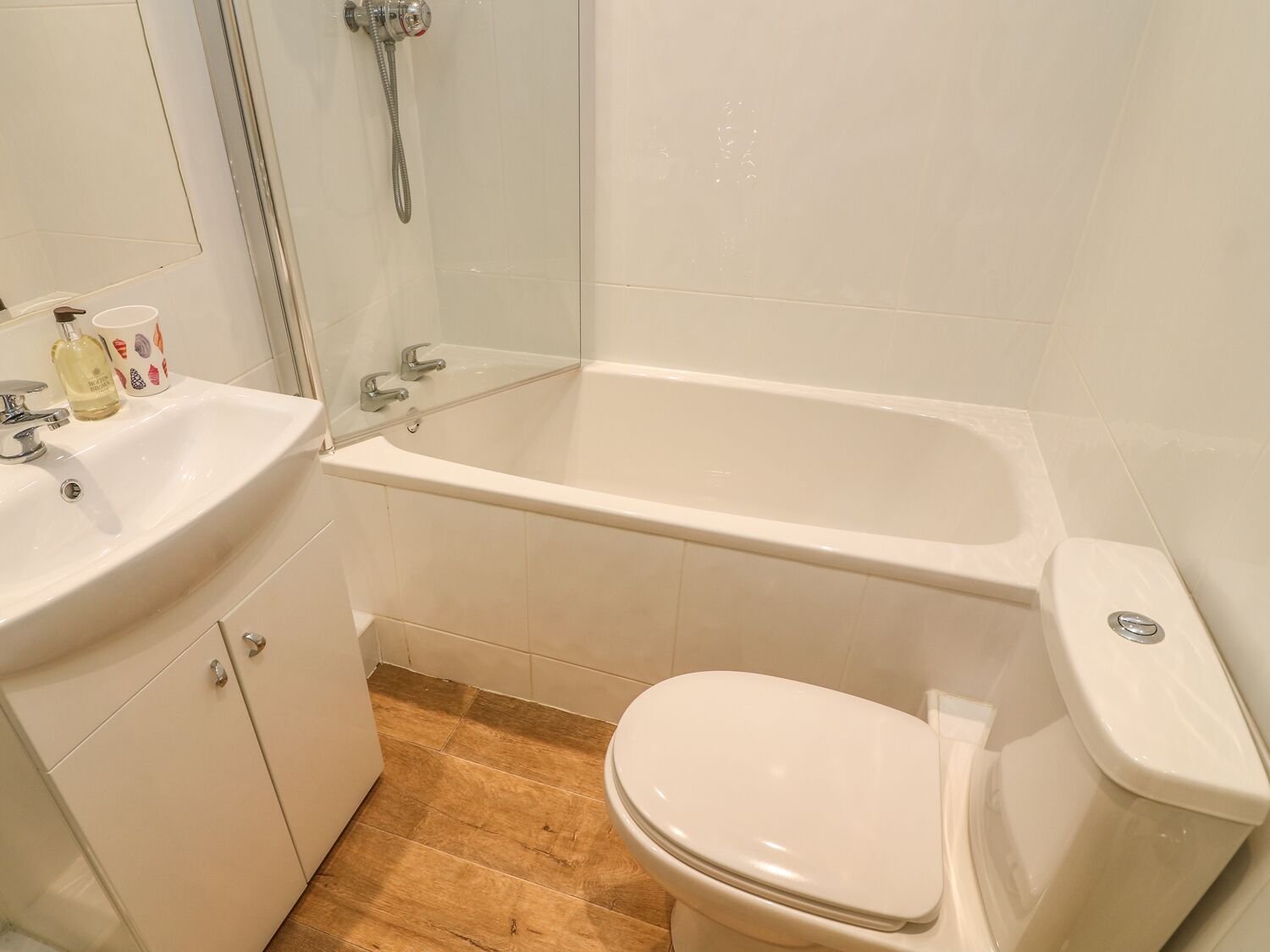 Een badkamer met een witte wastafel, een bad en een toilet.