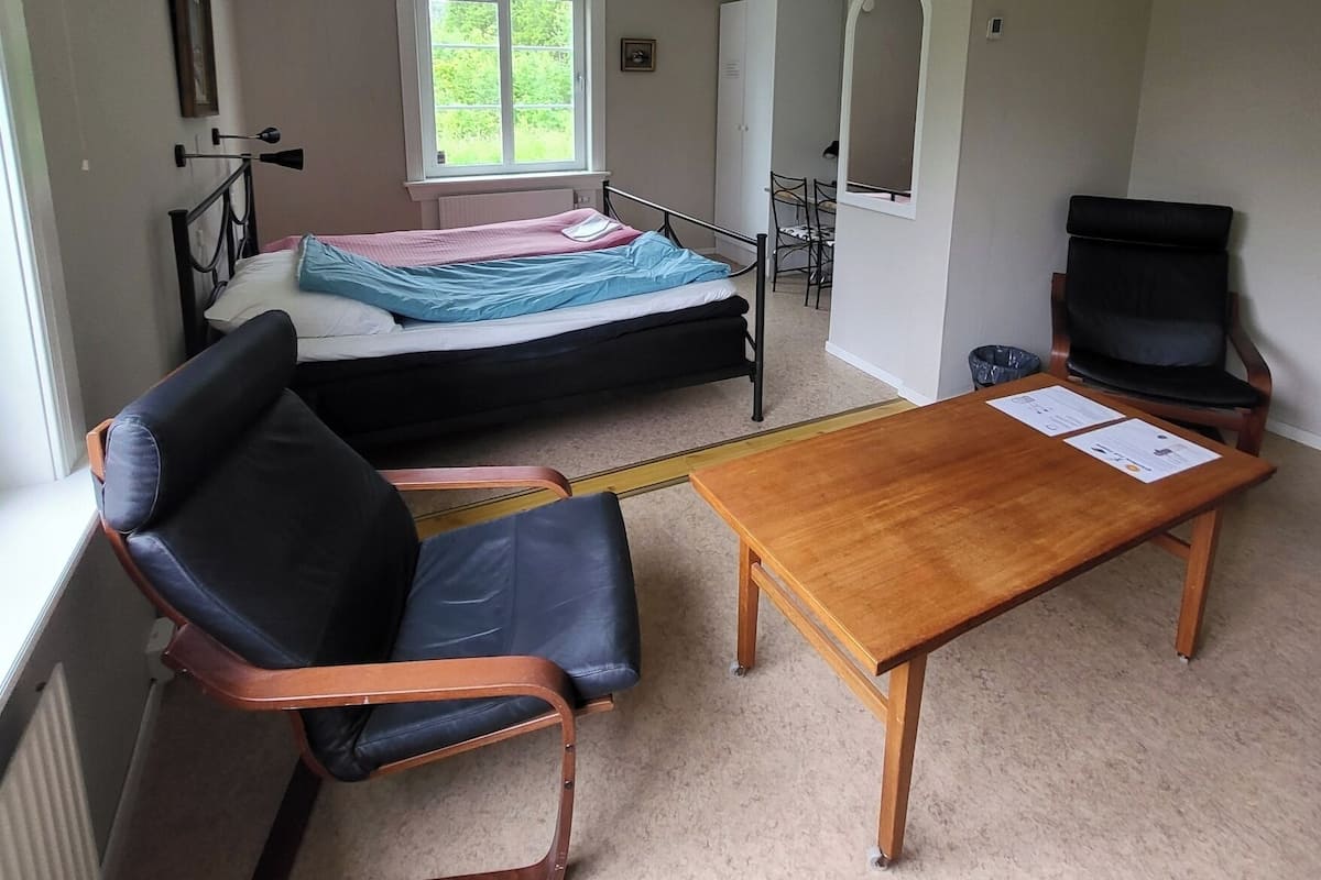 A compact room with a bed, a desk, a chair, and a television.