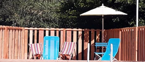 Una piscina al aire libre de temporada, sombrillas