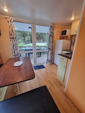 Enjoy casual dining and outdoor views from this kitchen area with a table, bench, and large window.