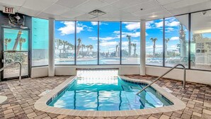 Un área de piscina con vistas a palmeras y un cielo despejado.