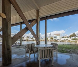 An outdoor patio with a view of a lake and houses, featuring a round table and two chairs. - Sea Pond Villa Unit 3 (North Myrtle Beach)