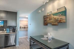 A modern kitchen with grey cabinets, a built-in coffee machine, and a dishwasher. - Sea Pond Villa Unit 3 (North Myrtle Beach)
