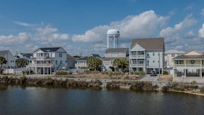 A waterfront residential area with houses, a water tower, and a dock. - Sea Pond Villa Unit 3 (North Myrtle Beach)